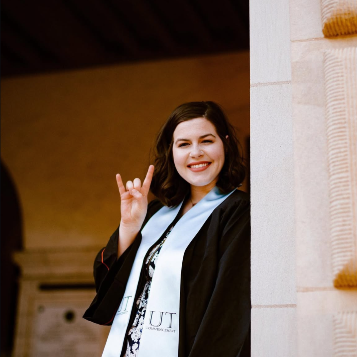 Smiling college graduate in cap and gown – celebrate their big day with custom graduation photo magnets by Spellbound Magnet Co.
