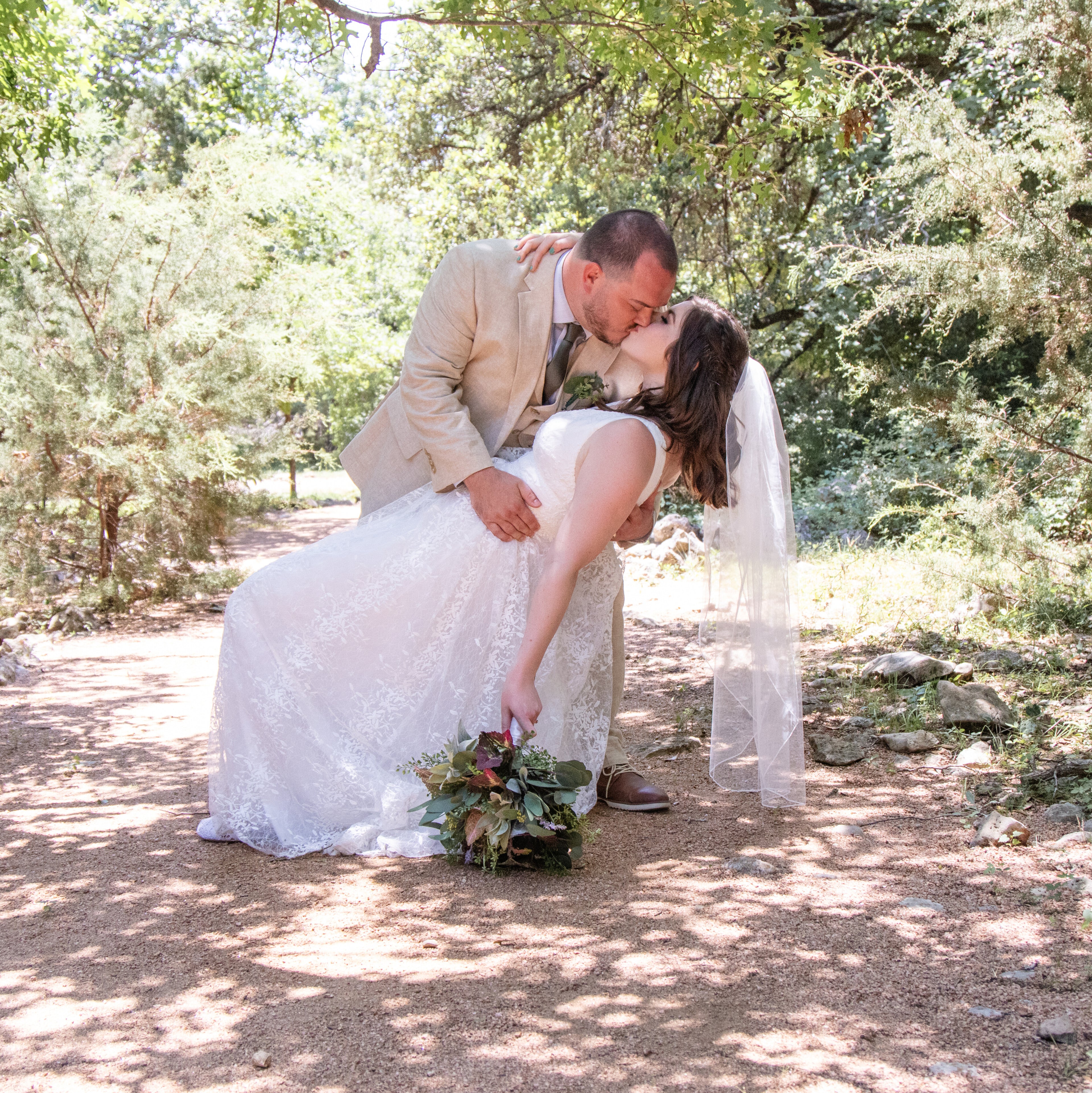 Bride and groom kissing outdoors on their wedding day – preserve your favorite wedding moments as custom photo magnets by Spellbound Magnet Co.