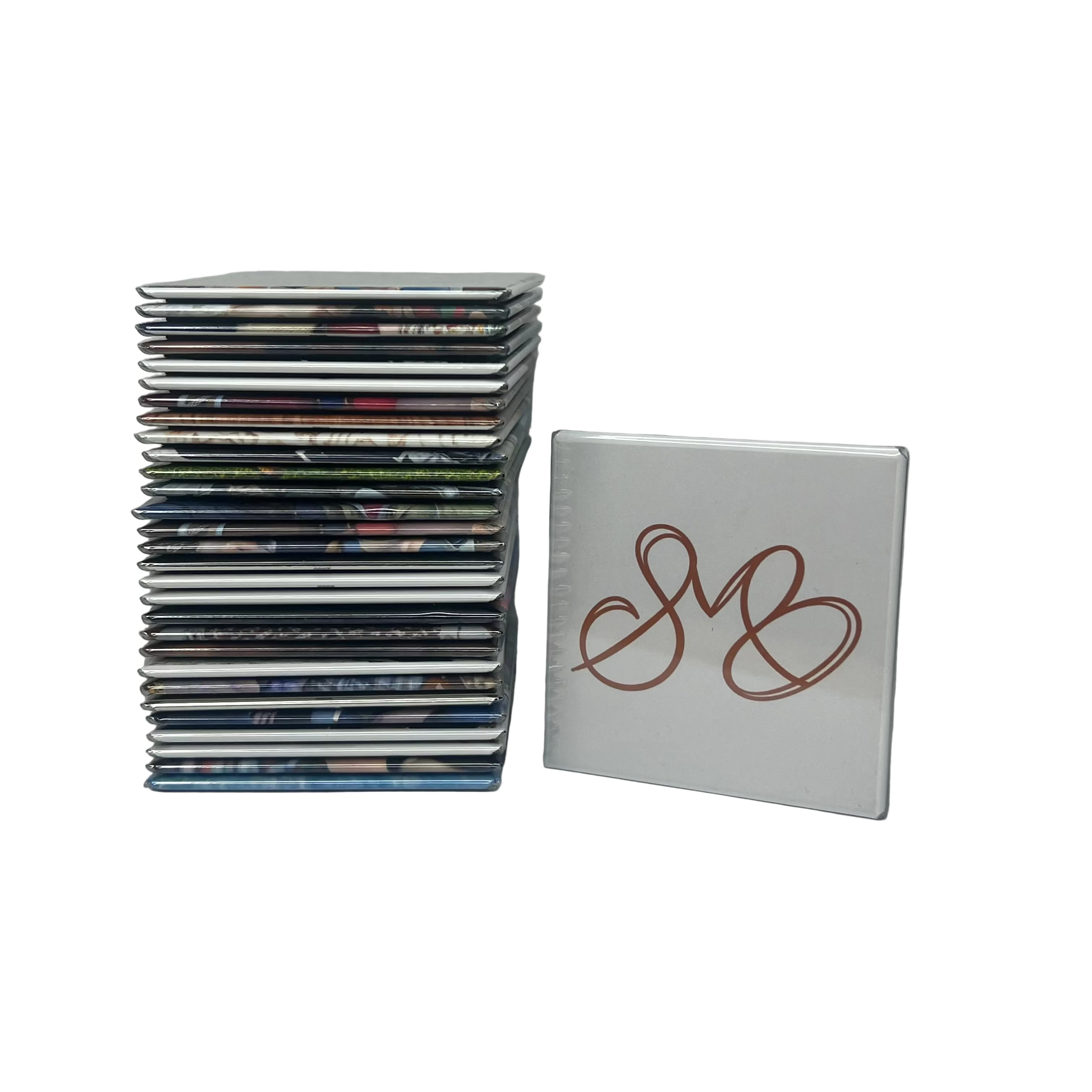 Stack of 30 Spellbound Magnet Co. custom photo magnets piled beside a single white magnet displaying the SMB logo in terracotta, shown against a white background.